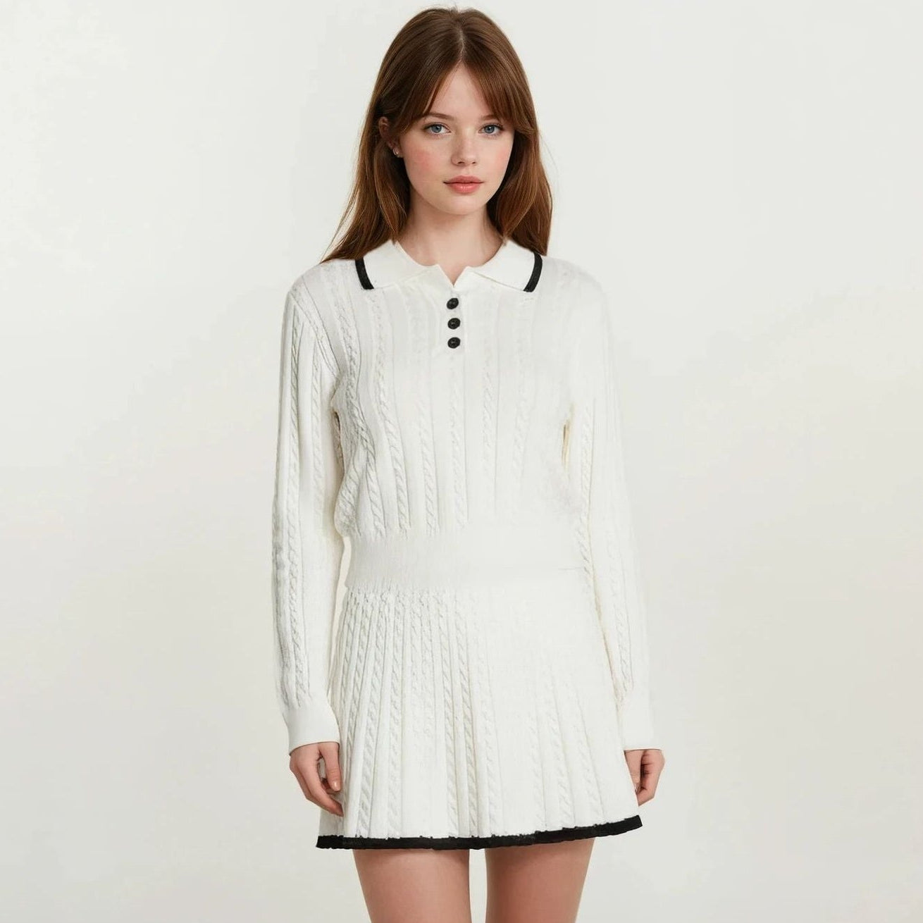 Woman wearing a white long-sleeve dress with black trim on a plain background