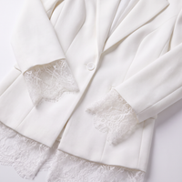 An off-white blazer with delicate white lace trim detailing the cuffs and hem, displayed on a clean white background.