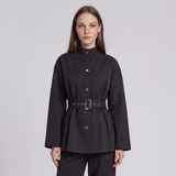 A model wearing a black long-sleeve peplum-style jacket with a high mock neck, front buttons, and a matching black belt with a silver buckle, set against a plain light gray studio background.
