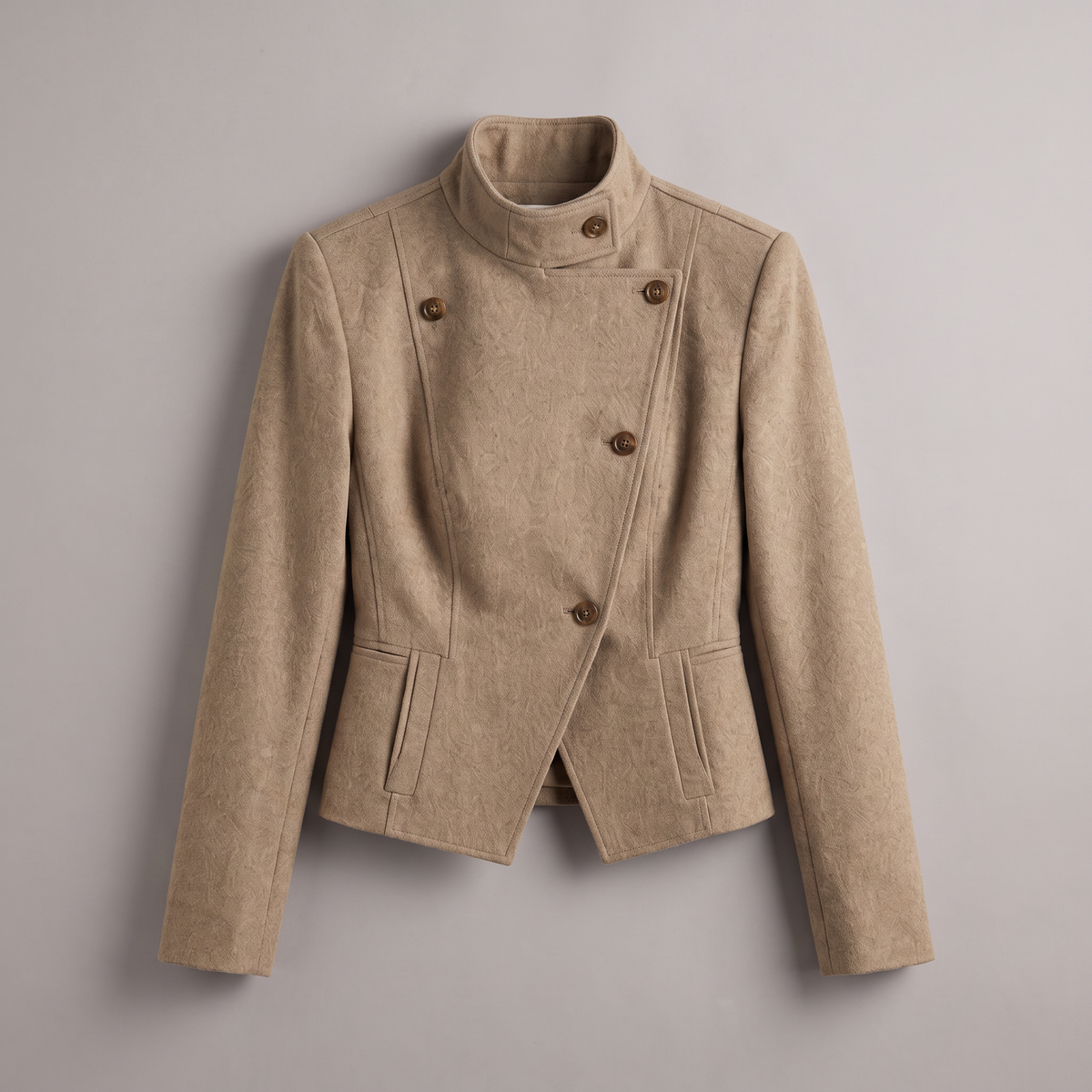A beige double-breasted wrap jacket with a high mock neck and brown buttons, displayed flat against a neutral gray background.